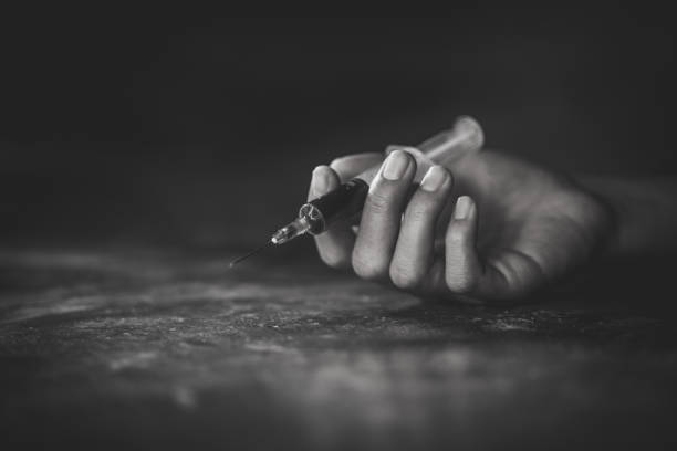 woman hand of a drug addict and a syringe with narcotic syringe lying on the floor, overdose, drug concept. - narcotic teenager cocaine drug abuse imagens e fotografias de stock