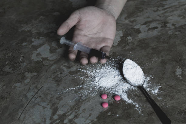 young woman  hand holding a syringe and drug overdose,the concept of crime and drug addiction. 26 june, international day against drug abuse. - narcotic teenager cocaine drug abuse imagens e fotografias de stock