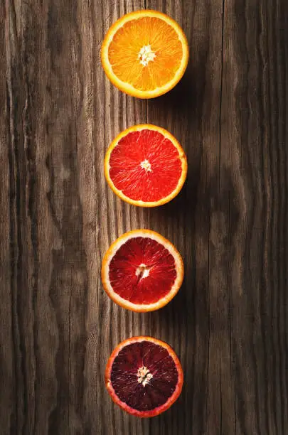 Orange fruit and blood orange on a dark wooden table