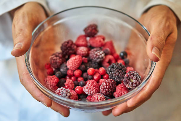 Fruit frozen wild berries in a bowl amerikanische heidelbeere stock pictures, royalty-free photos & images