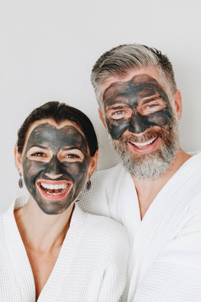 istock Happy couple wearing a charcoal mask 1127320473