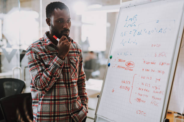 istock Bearded young man standing near the flipchart and thinking 1127320894