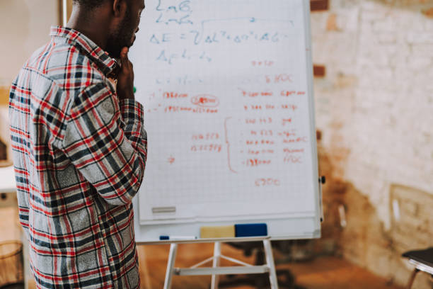 istock Rare view of thoughtful man standing with flipchart 1127320904