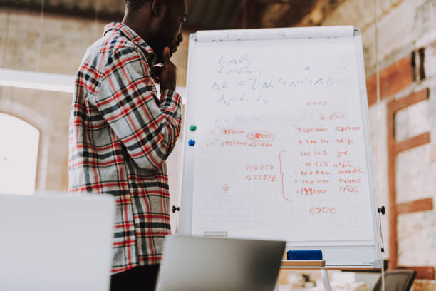 istock Serious man touching his chin while looking at the flipchart near 1127320905