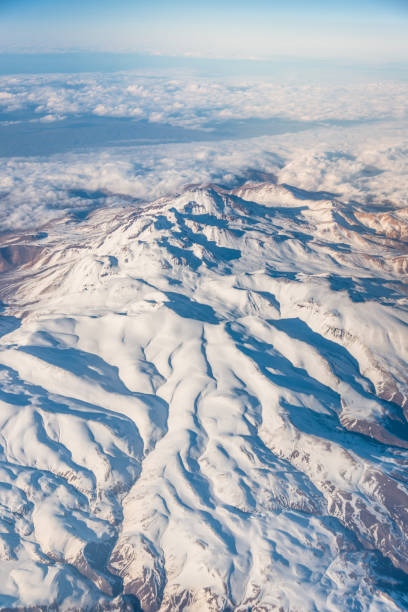 istock Wing of an airplane flying above the clouds with blue sky. 1127321649