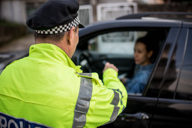 istock Police man giving a speeding ticket to a lady driver 1127322519