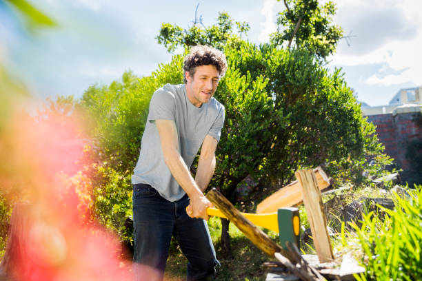 istock Man cutting logs with axe in yard on sunny day 1127322743