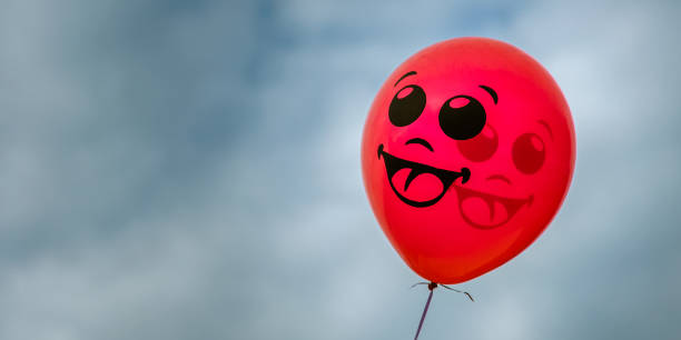 istock red balloon with a smile against the blue cloudy sky. copy space 1127324452
