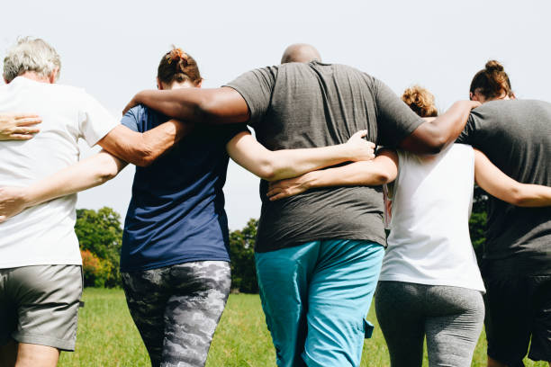 istock Group of people hugging in the park 1127326663