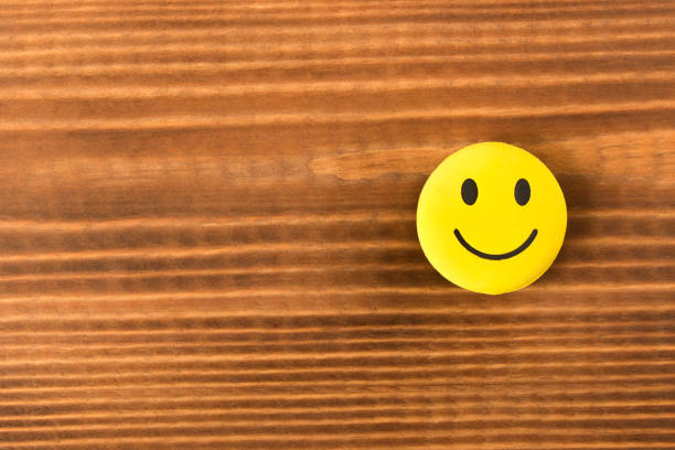 istock Funny smiley face on wooden background. Positive mood. Empty text space. 1127326720