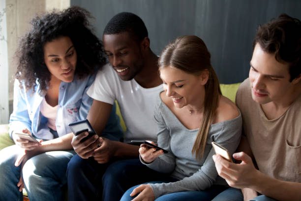 istock Happy multiracial people sitting in row, using phones together 1127327204