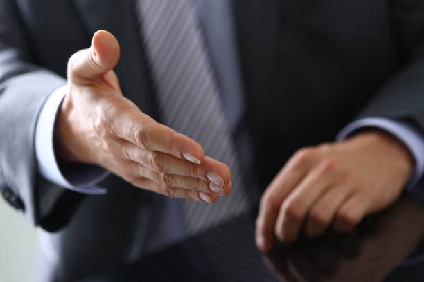 istock Man in suit and tie give hand as hello 1127330165