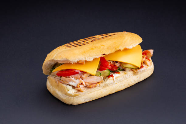 istock Ciabatta bread stuffed with cheese,meat and vegetables on dark background,selective focus and blank space 1127330951