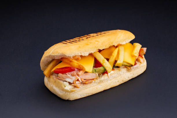 istock Ciabatta bread stuffed with cheese,meat and vegetables on dark background,selective focus and blank space 1127330959
