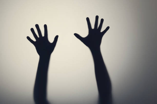 dark silhouette of woman hands behind glass door. concept of depression, fear, panic attacks - frosted glass glass textured bathroom imagens e fotografias de stock