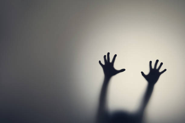 dark silhouette of woman hands behind glass door. concept of depression, fear, panic attacks - frosted glass glass textured bathroom imagens e fotografias de stock