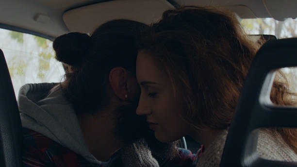 istock Young couple sitting in a retro car, cuddling and looking through the front window 1127331309