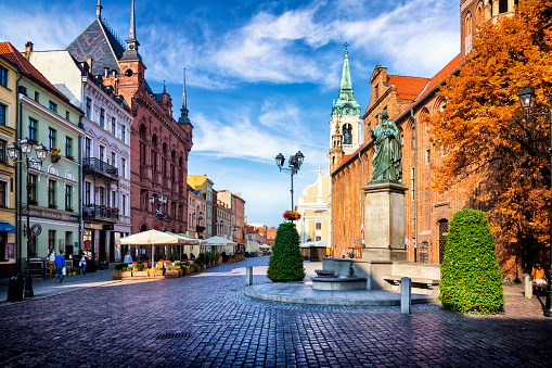 Torun, Poland - August 29, 2018:Morning view of the Old Town Market Square with monument of Nicolaus Copernicus and gothic Town Hall, Torun, Poland.