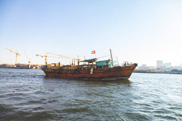 A usual summer day at Dubai Creek. Small boats also known as Abras powered by motors, used by daily commuters including expats, tourist and locals. Commercial vessels are often seen on the same waters of Creek docked either sides of the Creek. Towards the evening Creek also welcomes famous Dinner Cruises while during the day, tourist often charter smaller boats to explore Dubai on the Creek. One side of the Creek is known as Deira while the other side is known as Bur Dubai, both sides hold a large history of Dubai's Culture and Commercial Development.