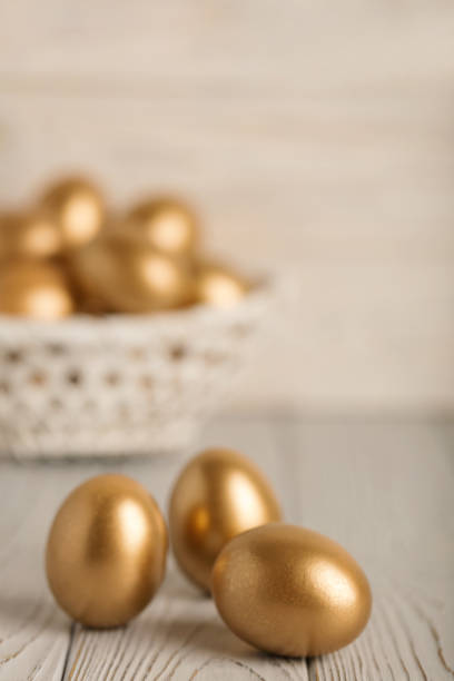 istock Happy easter! Easter eggs of golden color on a light wooden background. 1127336726