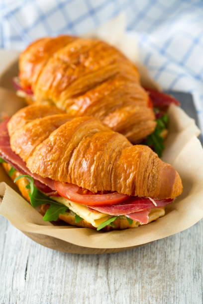 istock croissants with arugula, jamon, cheese and tomato on wooden surface 1127337882
