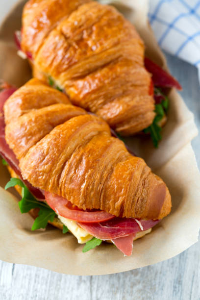 istock croissants with arugula, jamon, cheese and tomato on wooden surface 1127338009