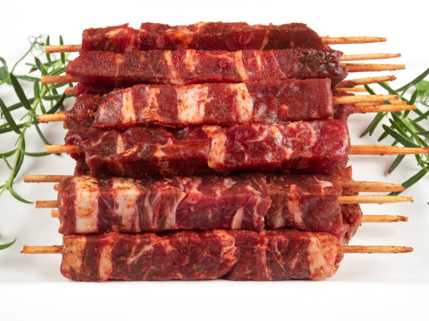 Raw fresh beef and lamb skewers, uncooked Raw fresh beef and lamb skewers, uncooked, on a white plate, garnished with fresh pea shoots and rosemary sprigs rosemary seedlings stock pictures, royalty-free photos & images