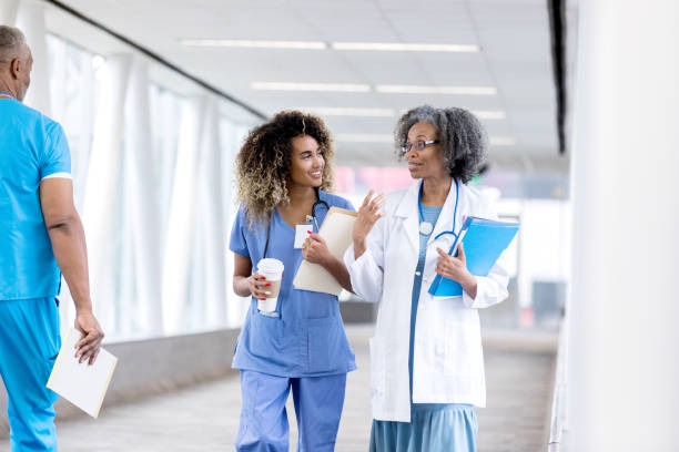 istock Attentive nurse talks withe doctor in hospital hallway 1127343742