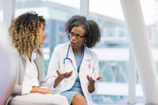 istock Serious doctor talks with young adult patient 1127343871