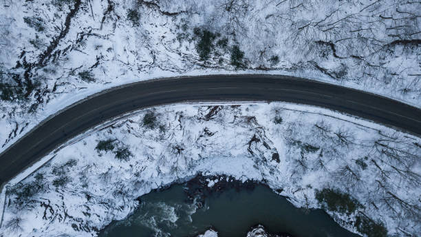 istock Curvy windy road in snow covered mountains, top down aerial view. 1127344426