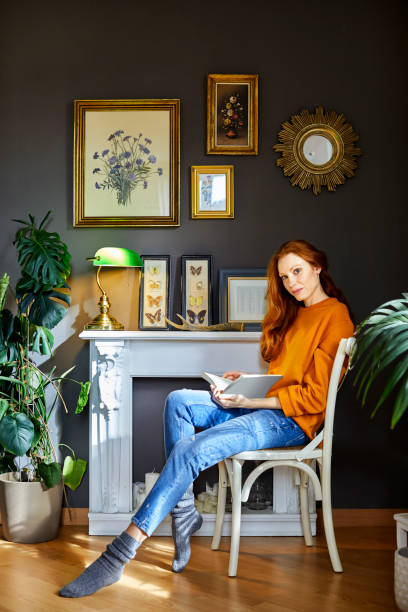 istock Beautiful woman reading book at home 1127345160