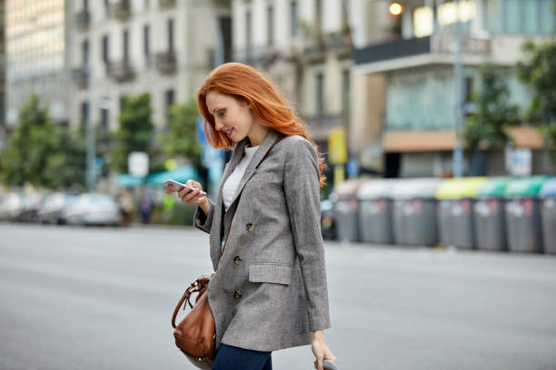 istock Young commuter walking on street using smart phone 1127345341