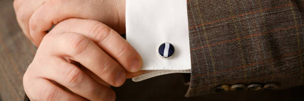 istock Male arm in brown suit set stud closeup 1127346167