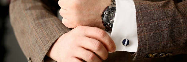 istock Male arm in brown suit set stud closeup 1127346169