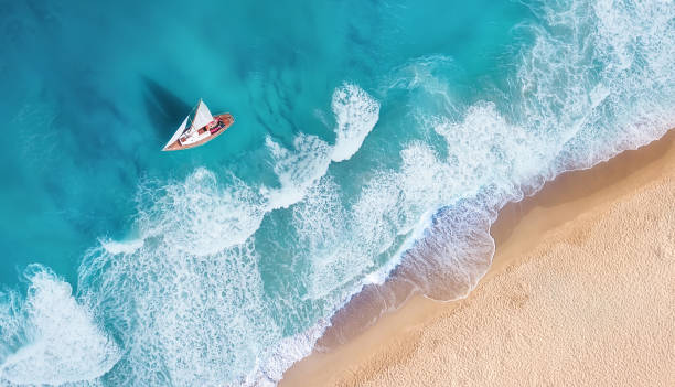 wellen und yacht aus draufsicht. türkisfarbenes wasser hintergrund aus draufsicht. sommer-seelandschaft aus der luft. draufsicht von drohne. reisen-bild - sailboat sailing yacht nautical vessel stock-fotos und bilder