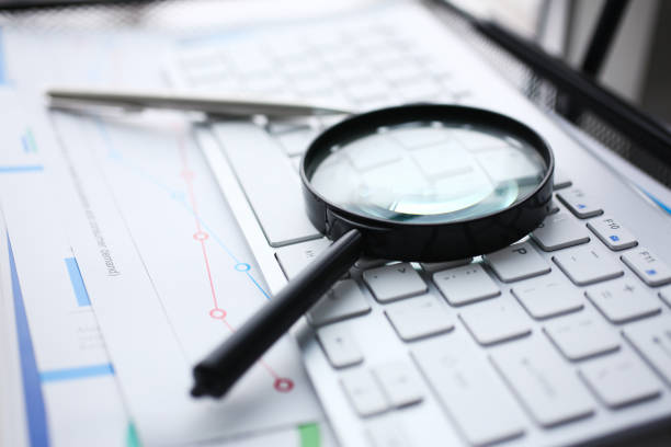 istock Magnifying glass lies on white keyboard 1127347042