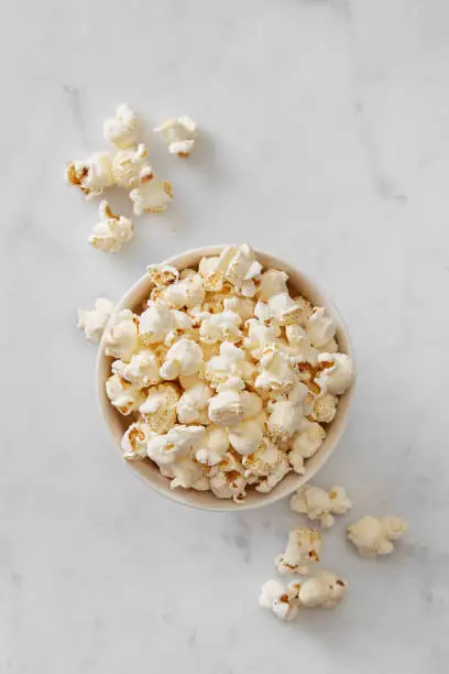 Photo of Pop corn bowl viewed from above on a marble background. Top view
