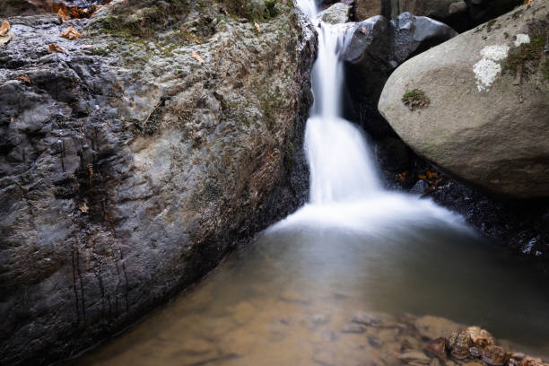 istock beautiful forest waterfall creek in long exposure in fall scenery 1127351216