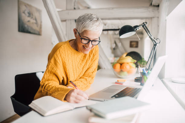 istock Mature woman writing 1127354017