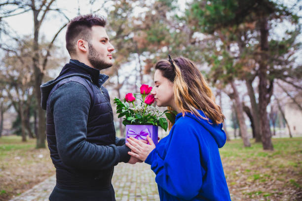 istock Young couple with a present in the park 1127354675