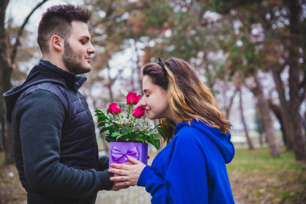 istock Young man gives flowers to girlfriend 1127354754