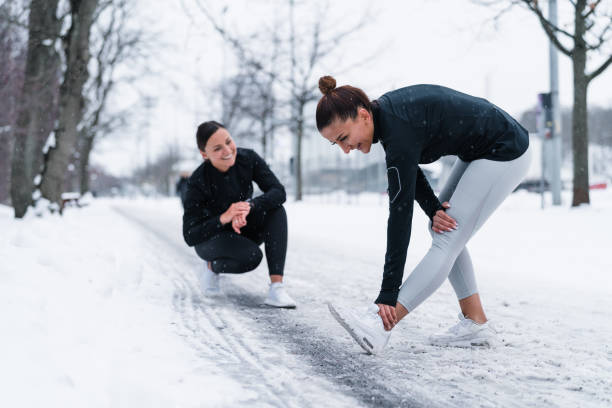 Two friends exercising in snow Two women are out in the snow on a cold winter day in Sweden, exercising together by jogging in the city. leggings stock pictures, royalty-free photos & images