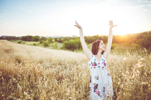 istock A beautiful young woman with spread hands in the wheat field. 1127355485
