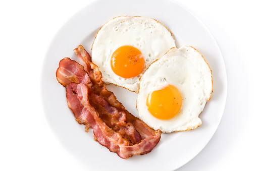 Fried eggs and bacon for breakfast isolated on white background.