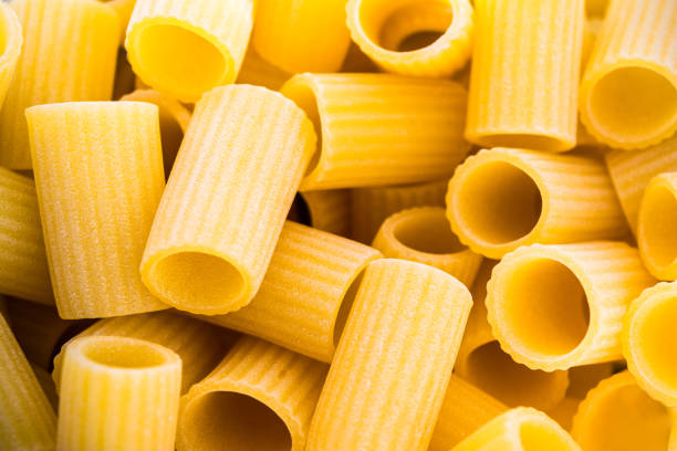 Large quantity of dry rigatoni type pasta Large quantity of dry rigatoni type pasta alimentazione non salutare stock pictures, royalty-free photos & images