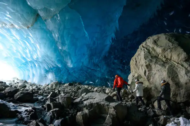 Guide and guests exploring a stunning glacial ice cave