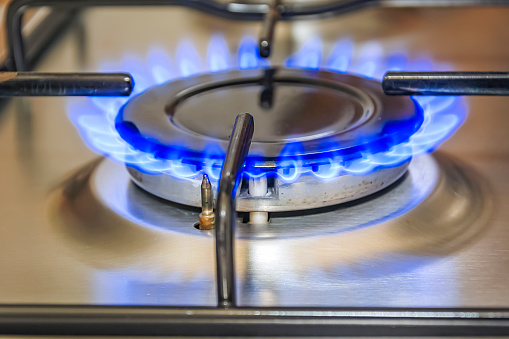 Close-up view of a kitchen cooker with blue flame. Cooking and gas energy concept