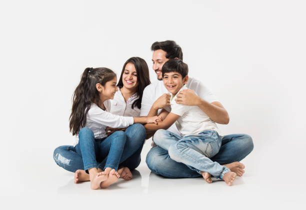 istock Young Indian/asian family sitting isolated over white background. selective focus 1127358907