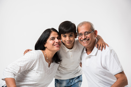 Indian/asian senior couple with grandson, isolated over white