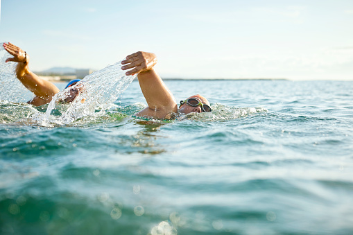 Photo of a mid-adult woman who is having daily swim training in the sea